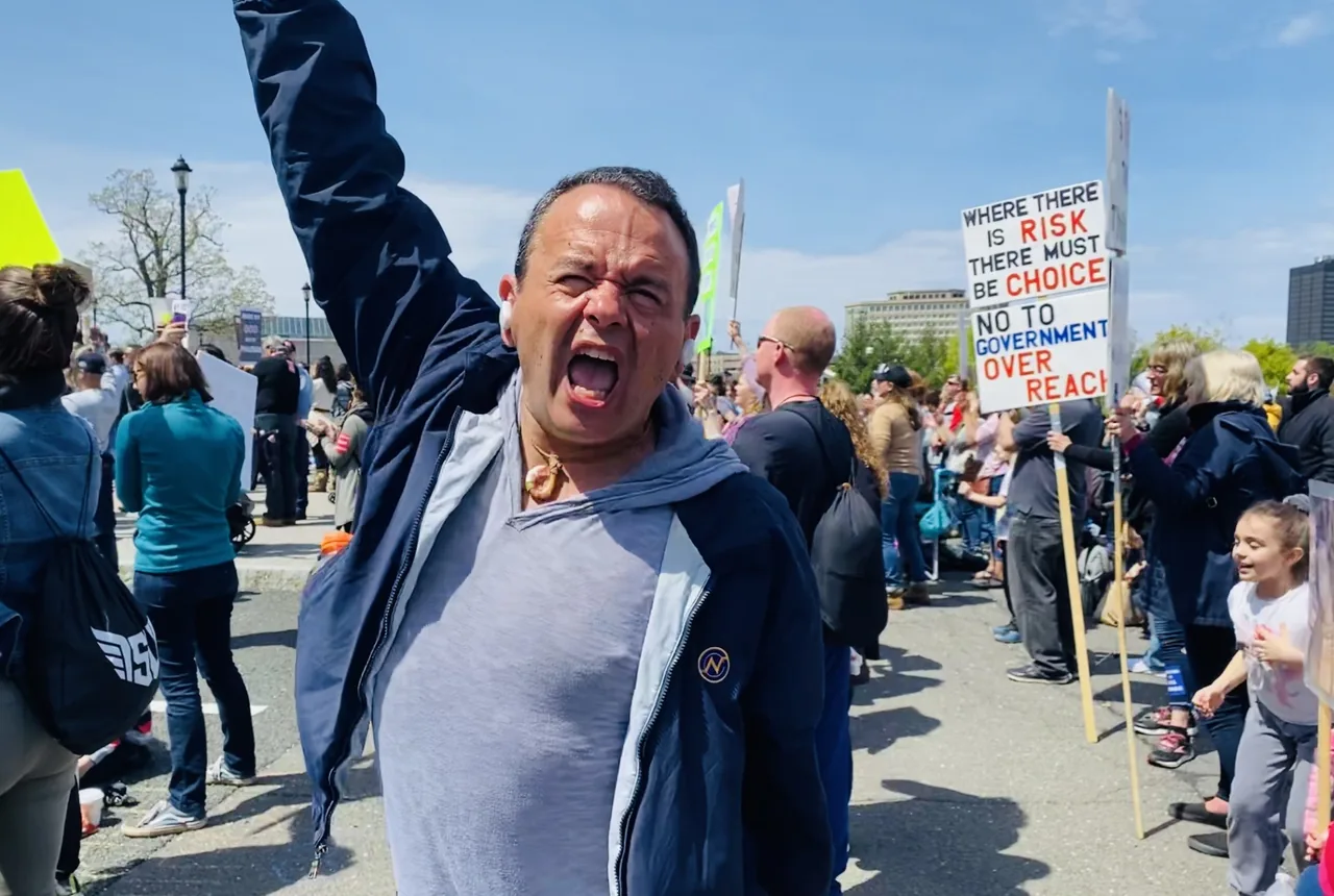 Dan Newmyer cheering among demonstrators holding signs at a Connecticut State Capitol rally